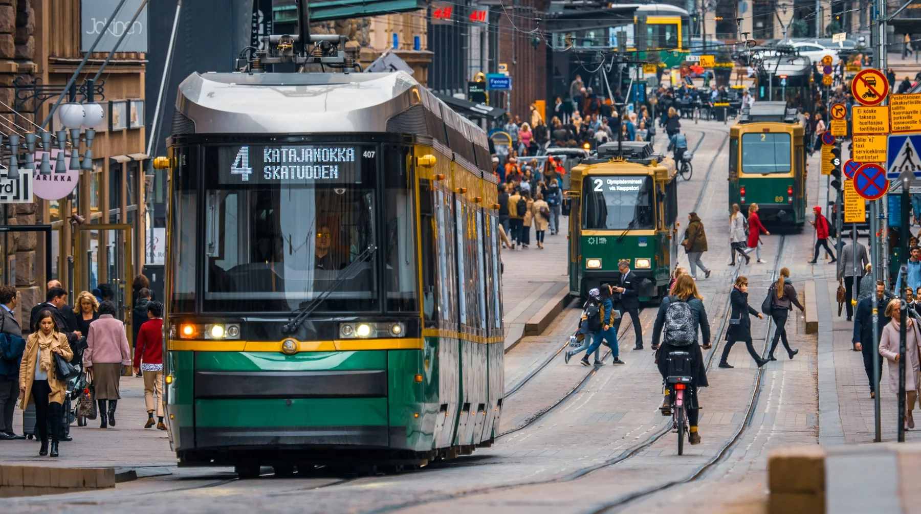 A tram and passers-by on a Helsinki street