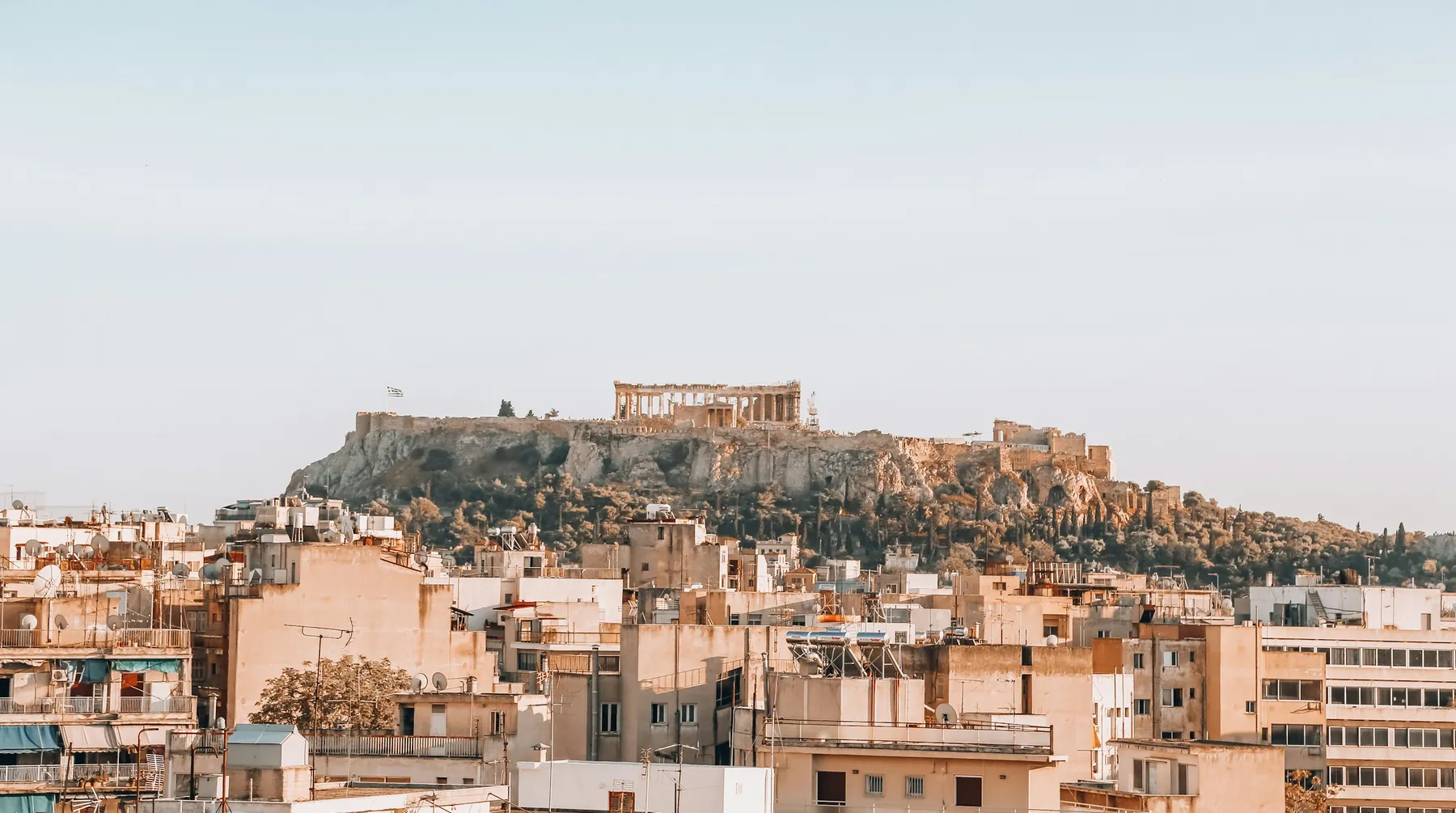Sergey Evdokimov holding apartment keys in front of the Acropolis in Athens