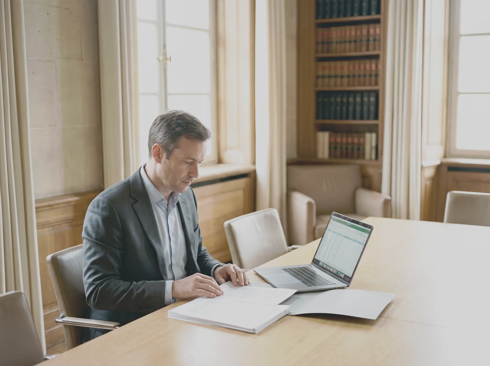 A specialist working with corporate data at a desk in a bright legal office