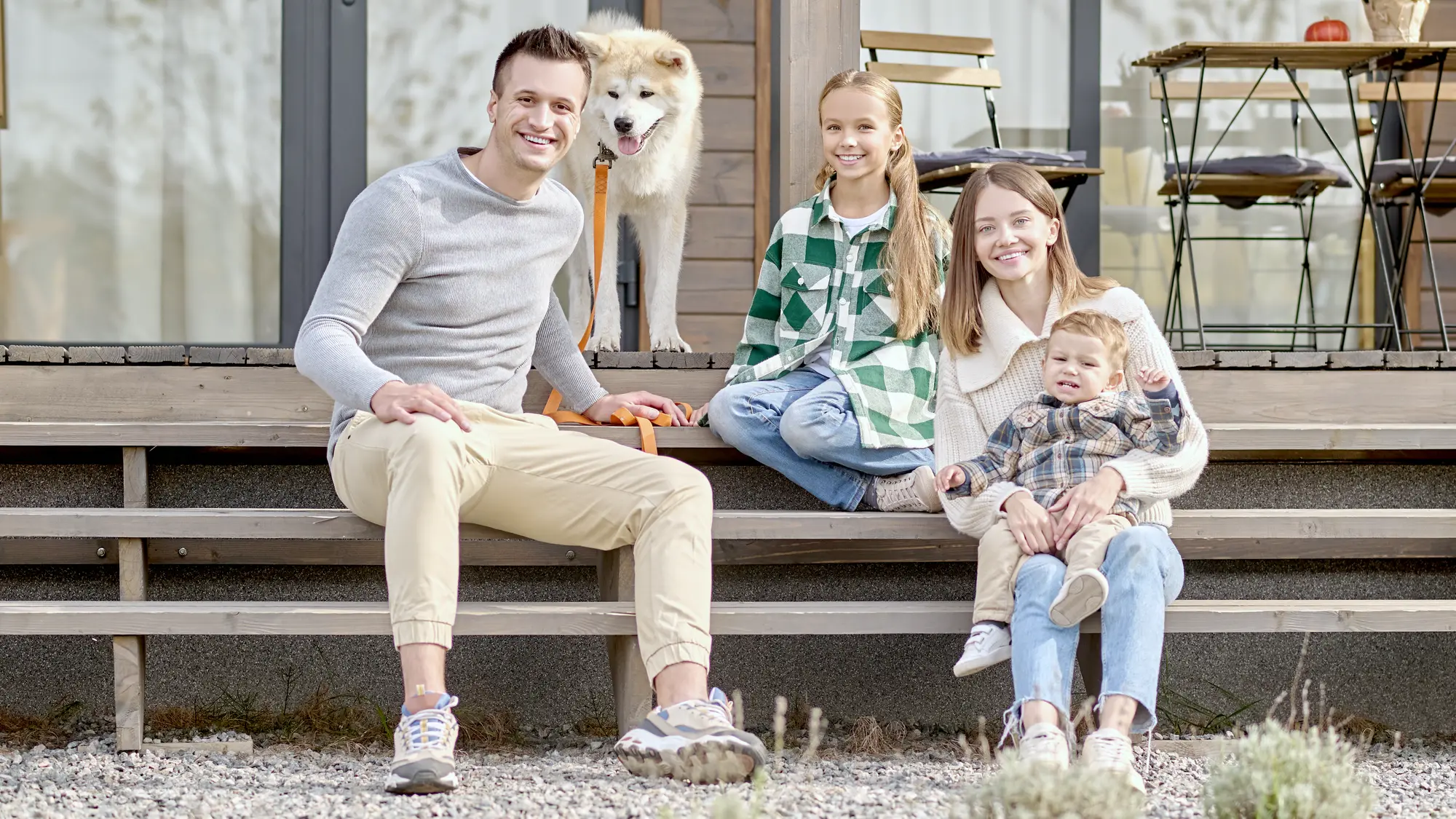A family with children and a dog on the steps of a house