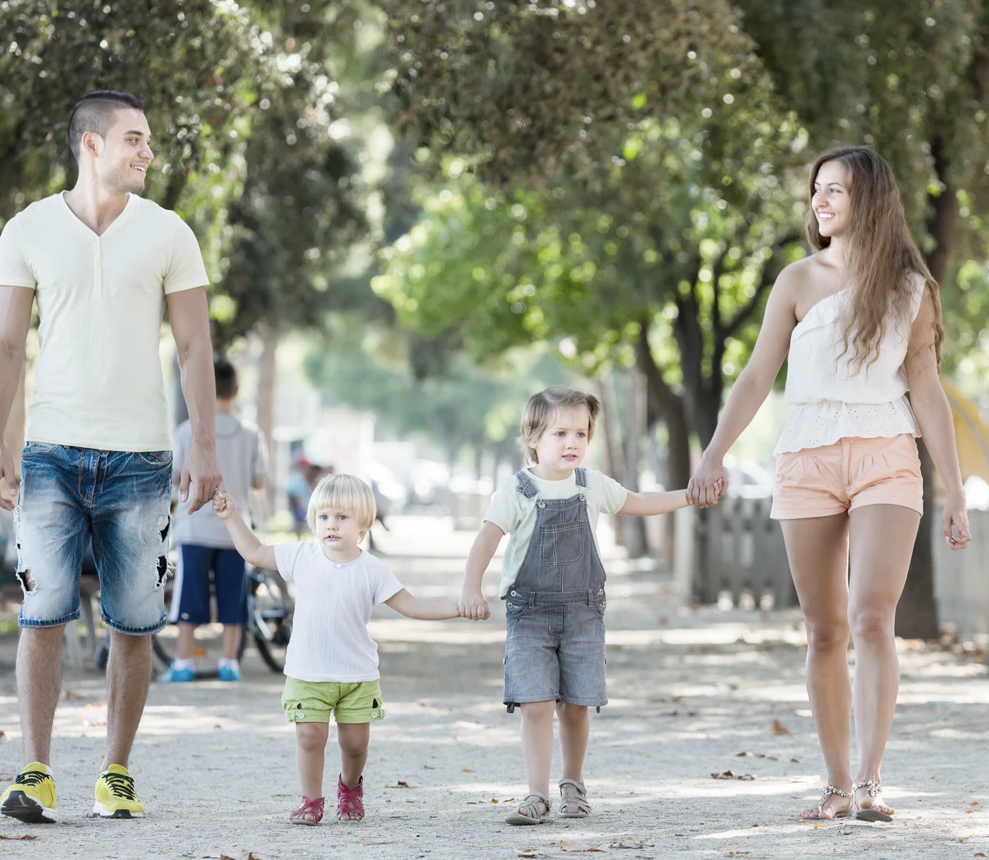 Parents with two children walking down a sunny street