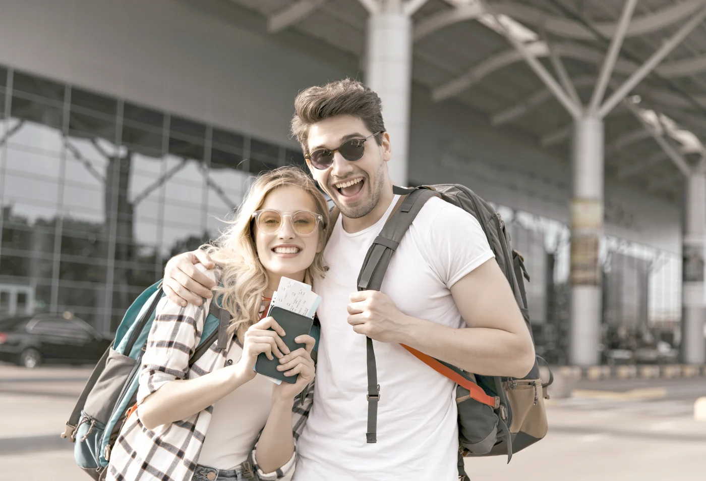 A couple with backpacks and passports at an airport