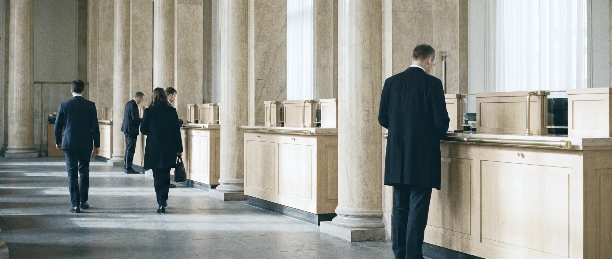 A government service hall: marble counters and visitors seen from behind