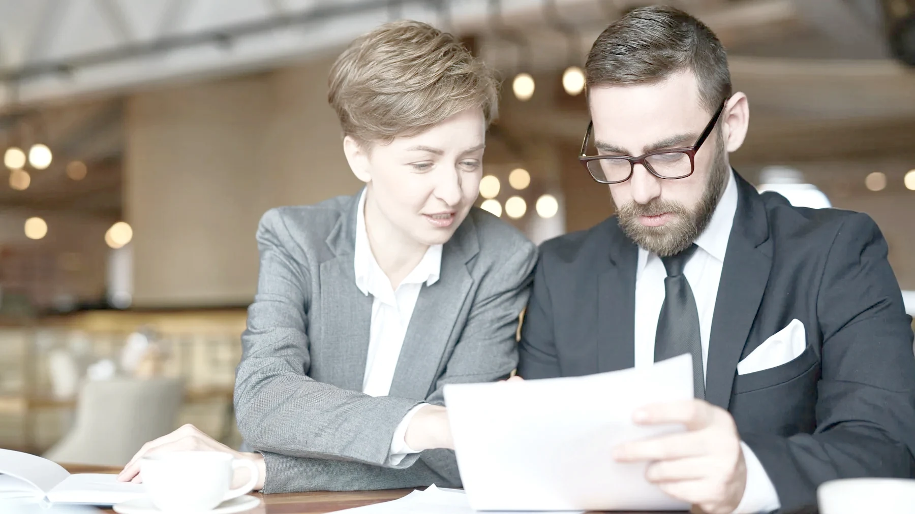 A lawyer and a client going through banking documents — updating self-certification after a change of residency